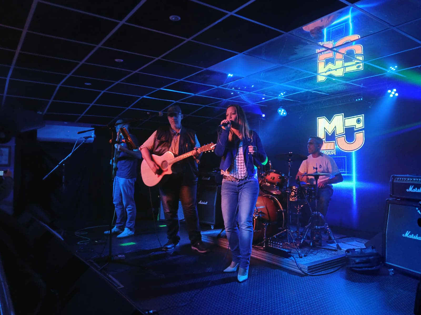 Le groupe sur scène, lumières bleues